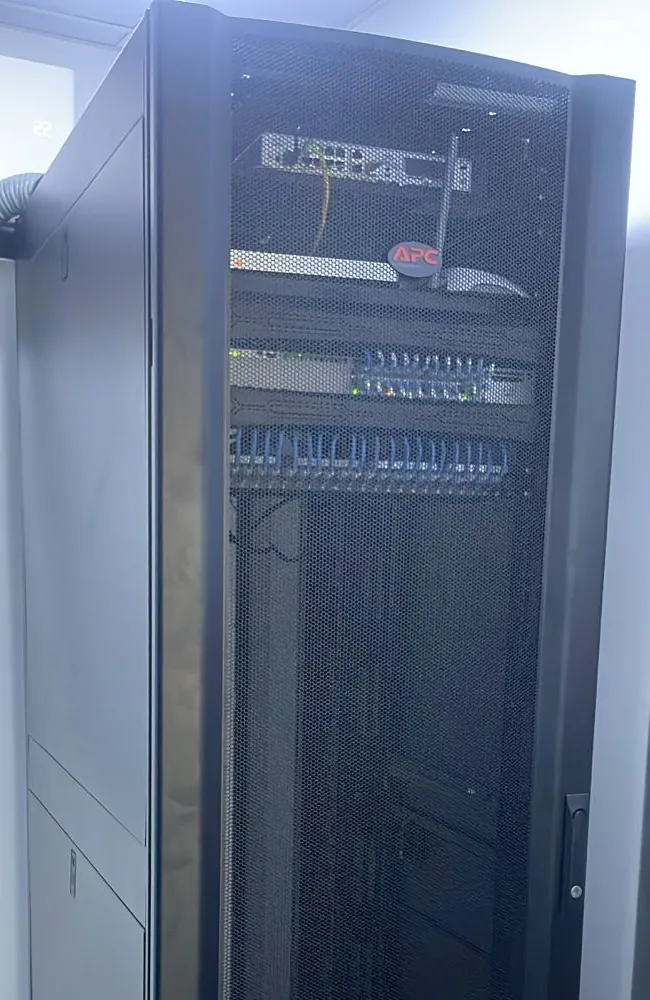 Rack APC del data center de EagleBurgmann con switch Cisco y cableado Cat 6